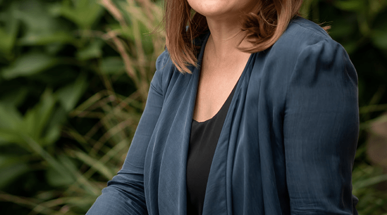 Trish Tanner seated outside near some plants