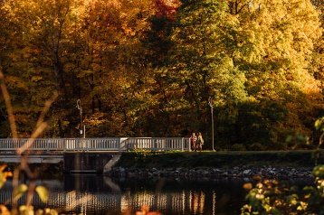 Students crossing the Lower Pond bridge in fall.