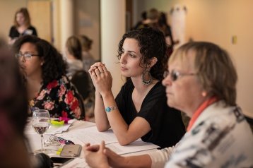 Professional and Graduate students listening attentively to a presentation