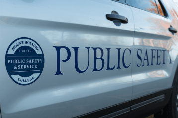 The side of a public safety and service vehicle, with a seal and the words "Public Safety" painted on the doors