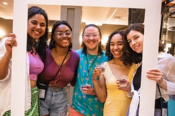 Students pose with "Strawberries and Champagne" polaroid cut out, 2021.
