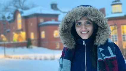 Ammal Abbasi on the wintery Mount Holyoke campus with a snow jacket and fuzzy hood.