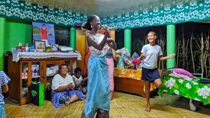 This is a picture of Yahzid smiling and dancing with a young girl in her homestay village.