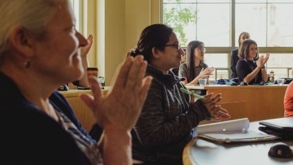 Audience members applauding a LEAP 2018 presentation.