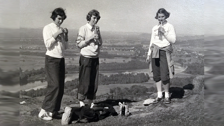 Three students drinking soda at the top of Mount Holyoke on Mountain Day 1940.