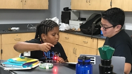 STEM Camp - Jen Matos with a student in a science lab.