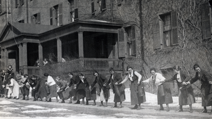 Students pass buckets full of water up a rope during fire drill, October 1920