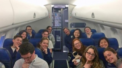 The riding team seated together on an airplane