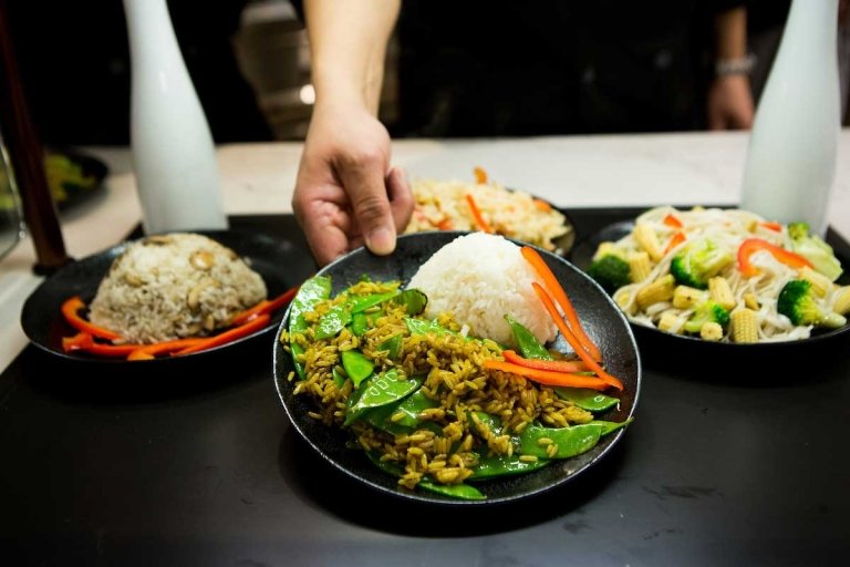 Plates full of stir-fried vegetable dishes from the wok station in the Dining Commons