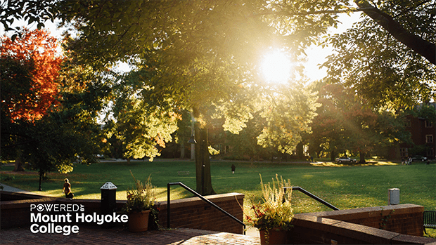 Powered by Mount Holyoke - sun's rays breaking through trees from the Blanchard entrance by Skinner Green