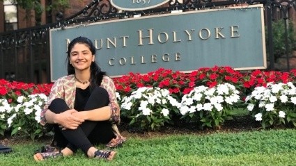 Ahlaam Abbasi by the Mount Holyoke College sign.