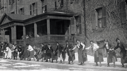 Students pass buckets full of water up a rope during fire drill, October 1920