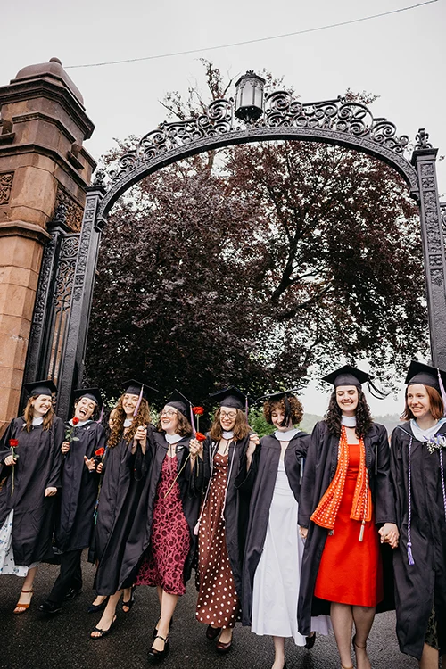 Students in caps and gowns walk through the gates after Commencement in 2026