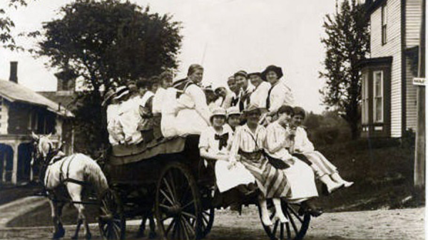 A group of first year students ride in a horse-drawn wagon on Mountain Day 1919.