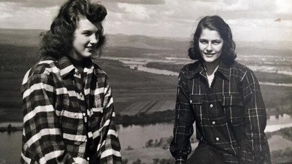 Two students dressed in flannel sit atop Mount Holyoke on Mountain Day 1947.