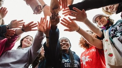 Students putting their hands in together on Mountain Day.