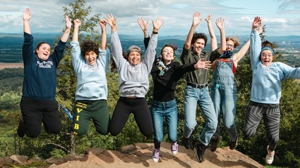 Students leaping into the air at the summit.