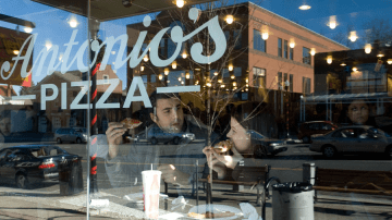 Two students enjoying a slice of pizza in Amherst