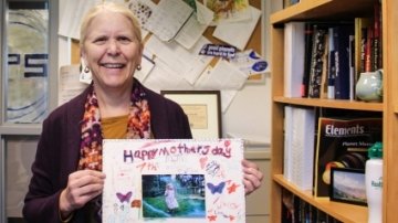 Darby Dyar in her office with a Happy Mother's Day poster