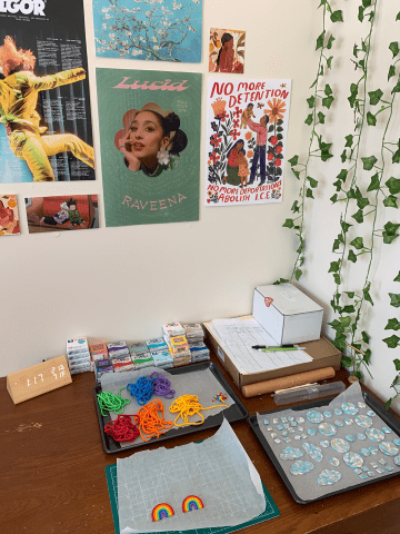 A student desk with materials laid out for making earrings