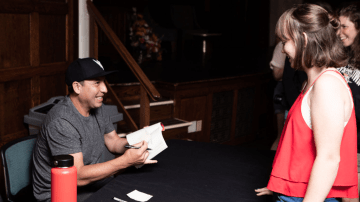 Tommy Orange (left) signs a student’s copy of “There There”