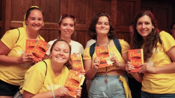 First year students in yellow holding copies of the Common Read