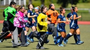 Field hockey - group of student athletes running across the field