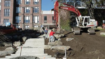 Photo of designer Julie Moir Messervey directing placement of stones during construction of the Heckel Staircase Garden