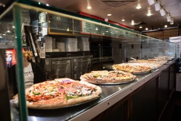 Pizzas lined up on display at Antonio's Pizza in Amherst, MA