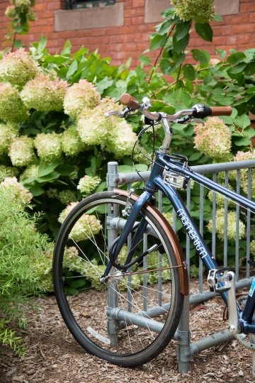 A blue bicycle locked to a bike rack