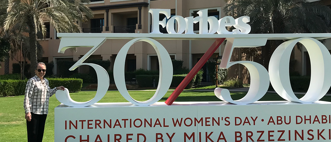 Interim President Beverly Daniel Tatum stands near a sign for International Women's Day in Abu Dhabi