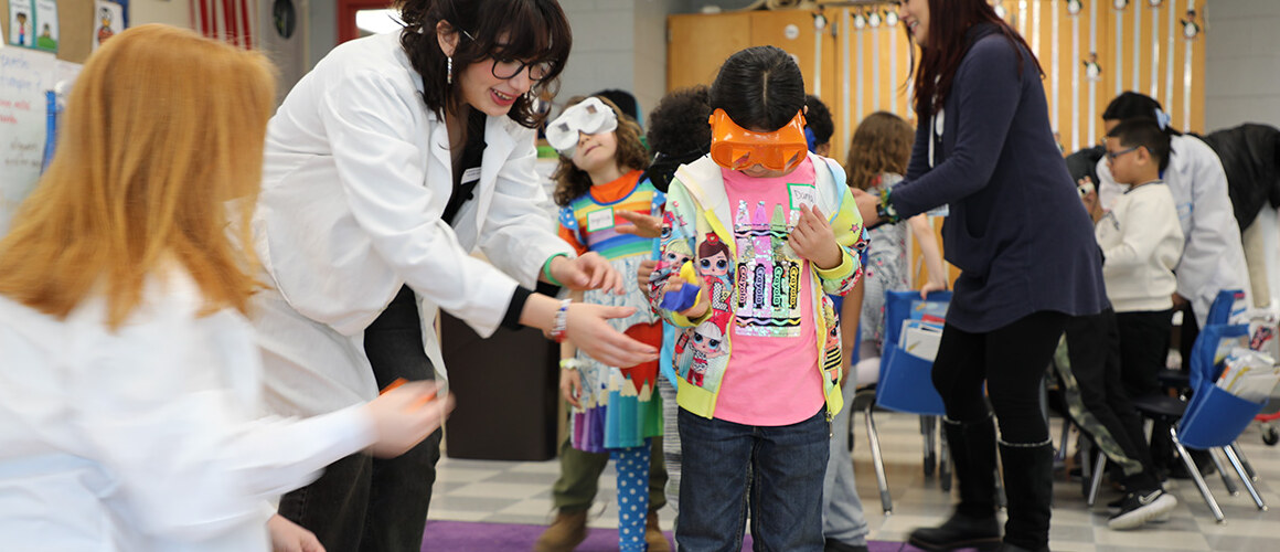 Mount Holyoke students guide first graders through goggle activity in Brain Basics workshop.