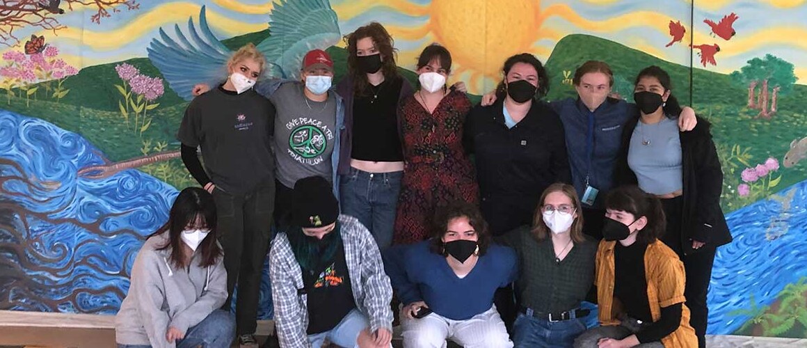 The group of students who worked on the Public Art mural, posing in front of the completed mural