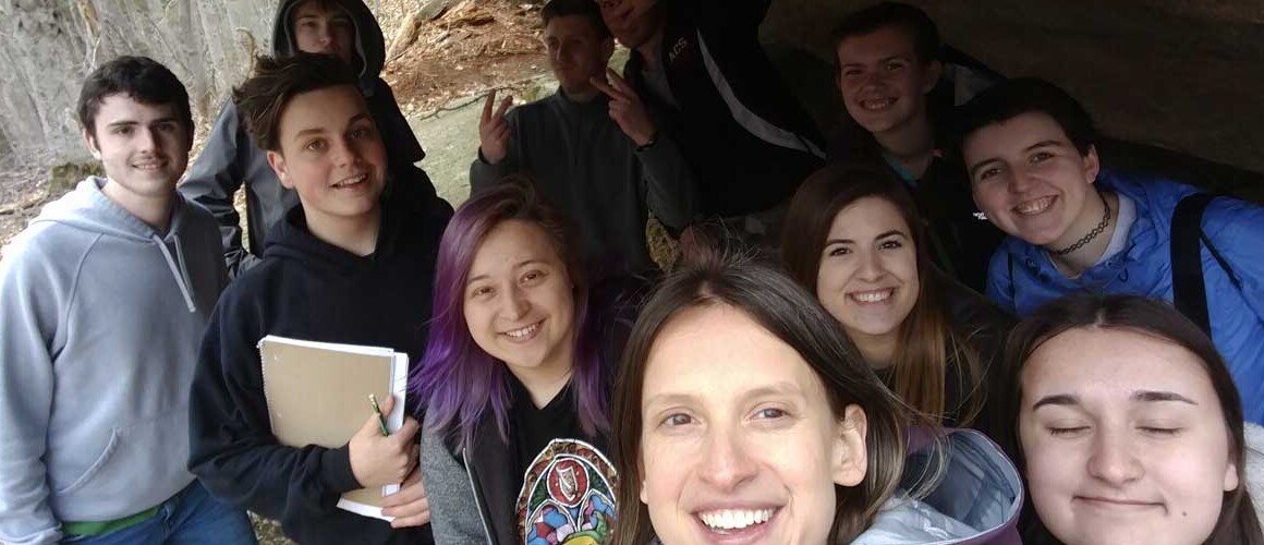 Katharine Hinkle ’02 and her geology students underneath a glacial erratic in Franconia Notch, NH.