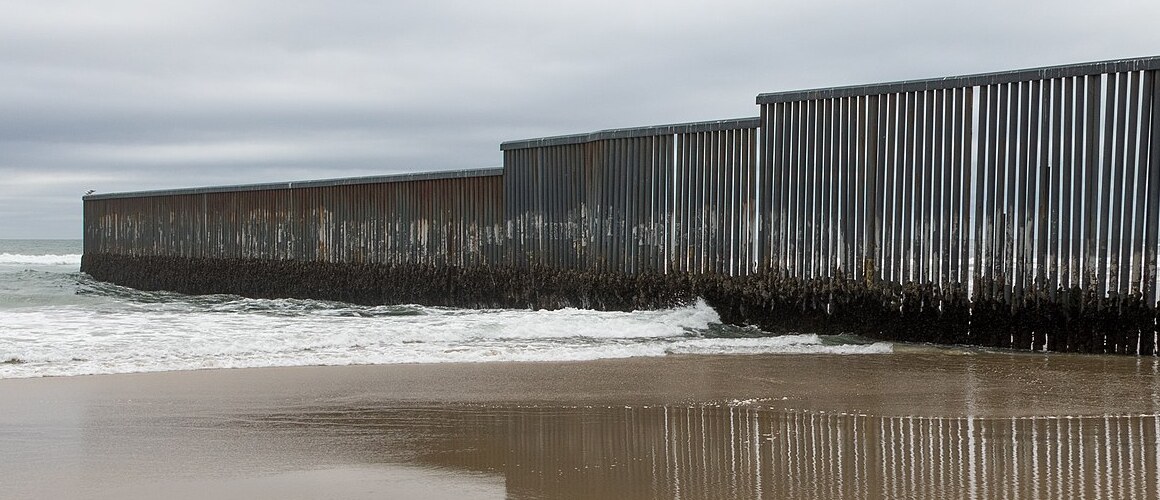 Mexico-US border wall at Tijuana, Mexico. Image courtesy of Tomas Castelazo, www.tomascastelazo.com, via Wikimedia Commons.
