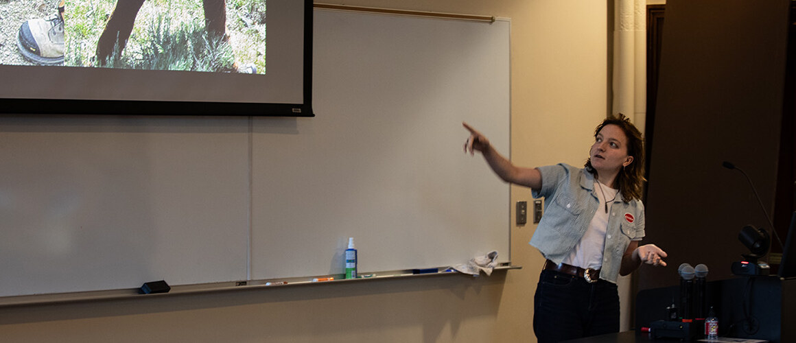 A student presents in front of a screen.