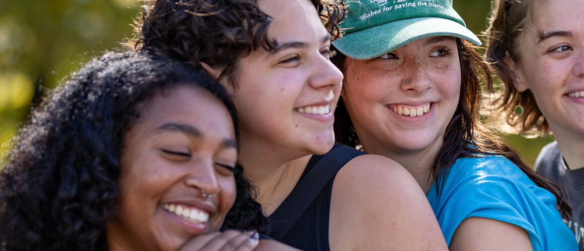 Four friends - Mount Holyoke students - pose for a photo at the top of Mt. Holyoke on Mountain Day, 2025. Photo by Max Wilhelm.