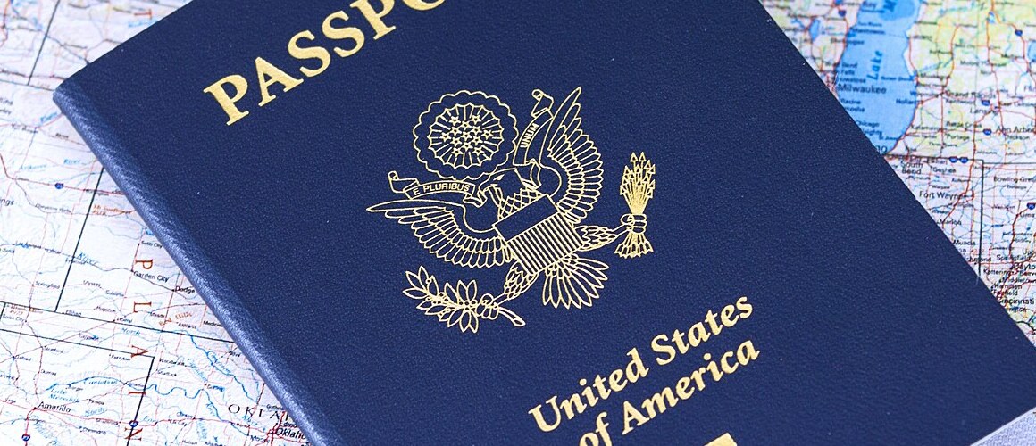 A blue American passport lies atop a map of the world.