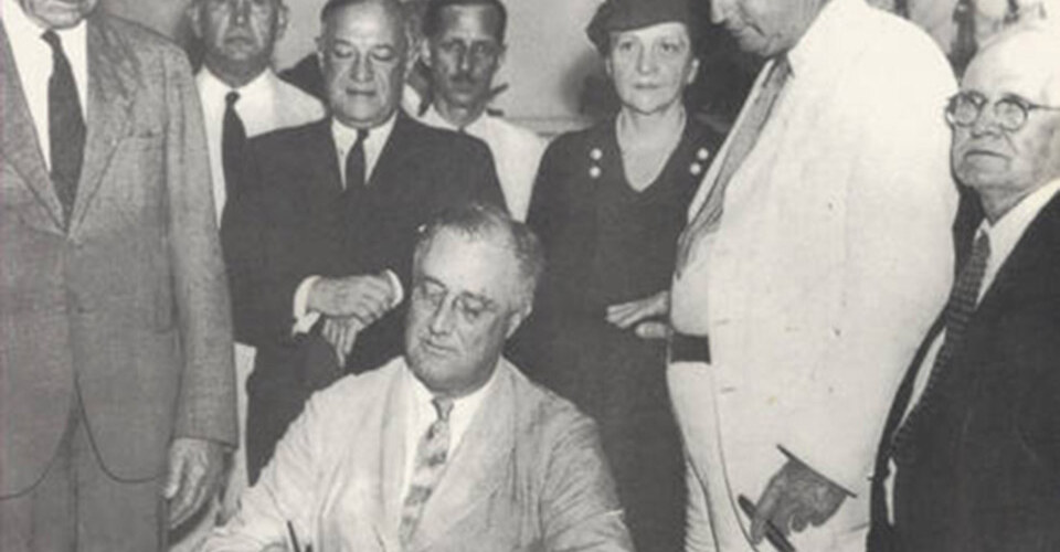 Frances Perkins, a key champion of the New Deal, watches President Roosevelt sign the Social Security Act. Photo MHC Archives