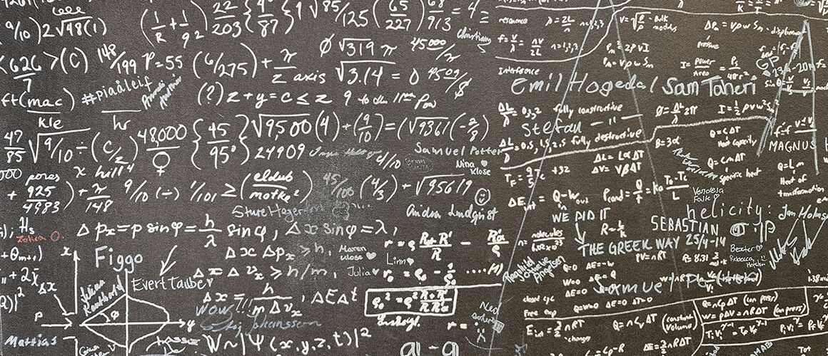 Math equations and formulas on a chalk board.