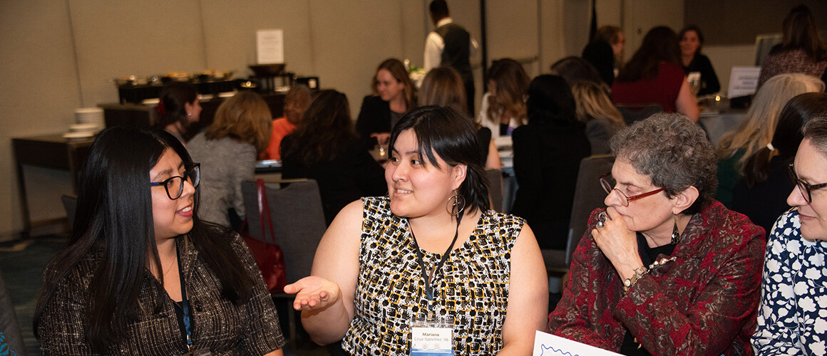 Mount Holyoke College alums and students at the Education and Social Impact table at the alum networking reception.